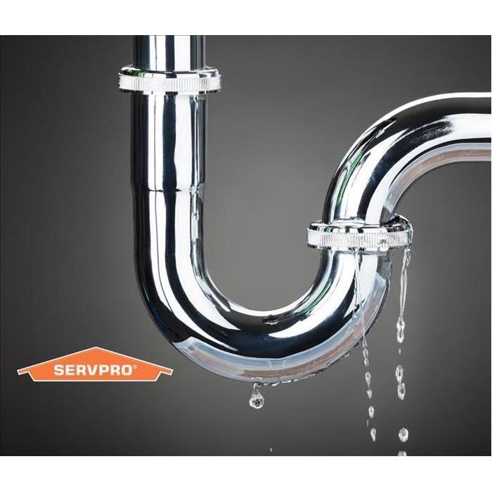 Plumbing Stainless Steal U trap leaking with Servpro logo on bottom left