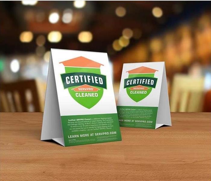 2 Certified: SERVPRO Cleaned signs on a wooden table