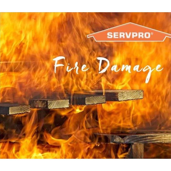 Wooden foundation engulfed in flames with the words "Fire Damage" and the SERVPRO logo on top right