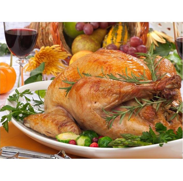 Delicious Baked Turkey on a platter along fruits and a glass of red wine